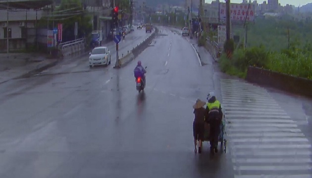 急人之難！峽警冒雨助八旬阿嬤推車安全過路口